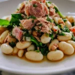 Bowl of tuna and white bean salad garnished with fresh herbs
