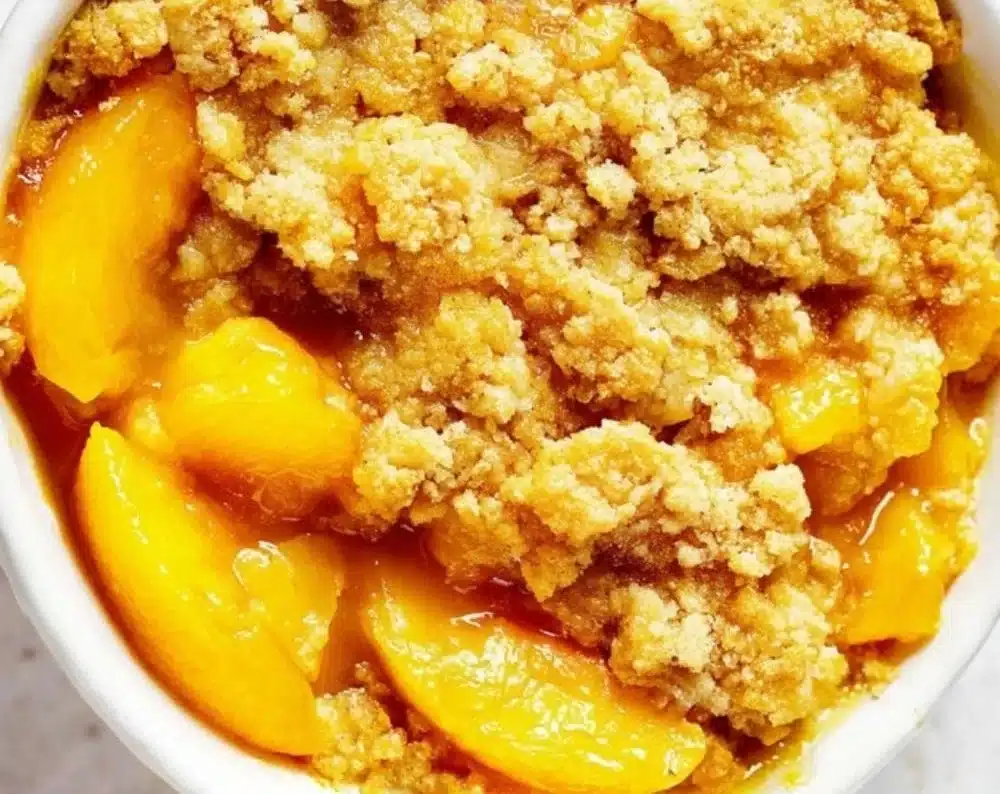 Easy peach cobbler dump cake made with cake mix, served in a baking dish.