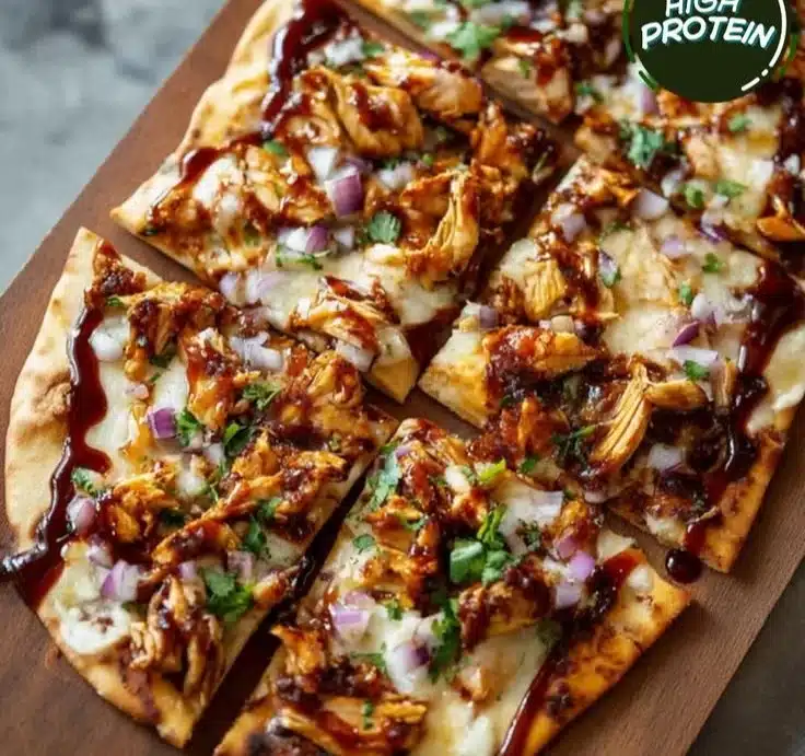 Savory BBQ chicken flatbread topped with fresh ingredients and drizzled with BBQ sauce.