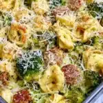 Sheet pan broccoli tortellini bake topped with cheese and fresh herbs