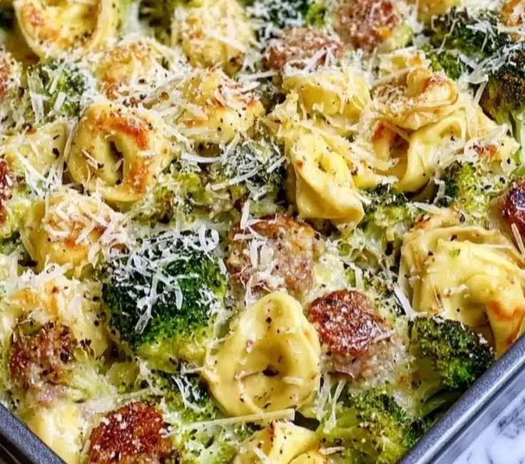 Sheet pan broccoli tortellini bake topped with cheese and fresh herbs