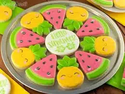 Colorful summer themed cookies shaped like sun, beach, and flowers.