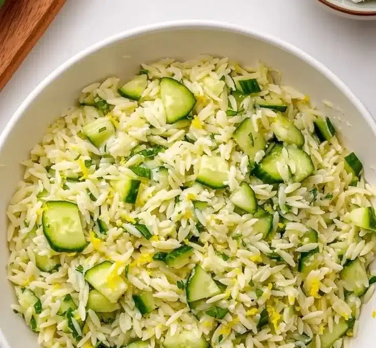 Zesty Cucumber Lemon Orzo Salad served in a bowl with fresh herbs and vegetables