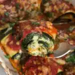 Zucchini Rollatini filled with ricotta and herbs, topped with marinara sauce.