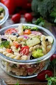 Colorful bowl of best summer pasta salad with fresh vegetables and herbs