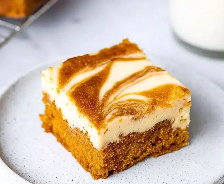 Delicious Carrot Cake Cheesecake Bars topped with cream cheese frosting.