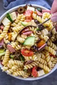 Delicious cold pasta salad served in a bowl with vegetables and dressing