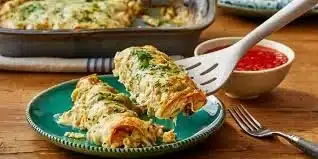 Delicious white chicken enchiladas with creamy white sauce served on a plate