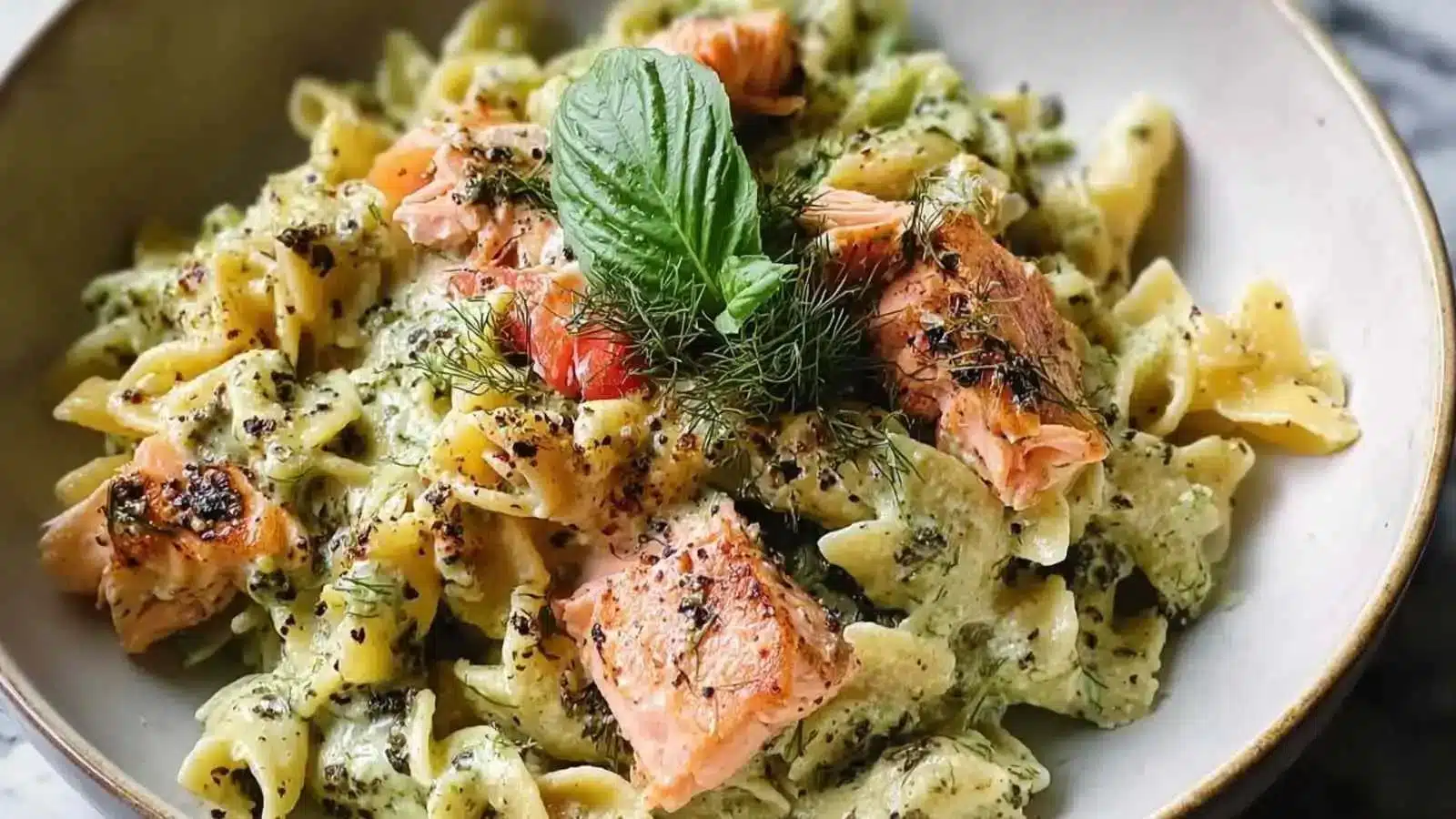 Delicious creamy salmon pesto pasta with fresh ingredients served in a bowl
