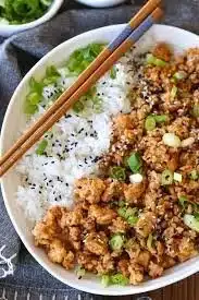 Variety of healthy ground chicken recipes on a wooden table