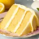 A delicious lemon layer cake with fresh lemon frosting and garnished with lemon slices.