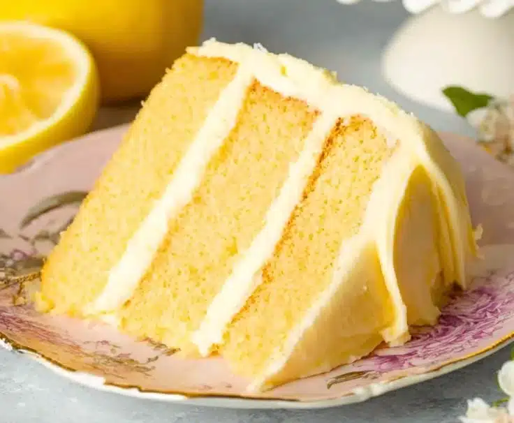 A delicious lemon layer cake with fresh lemon frosting and garnished with lemon slices.