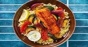 Plated Lemon Yogurt Salmon with Roasted Veggies garnished with herbs