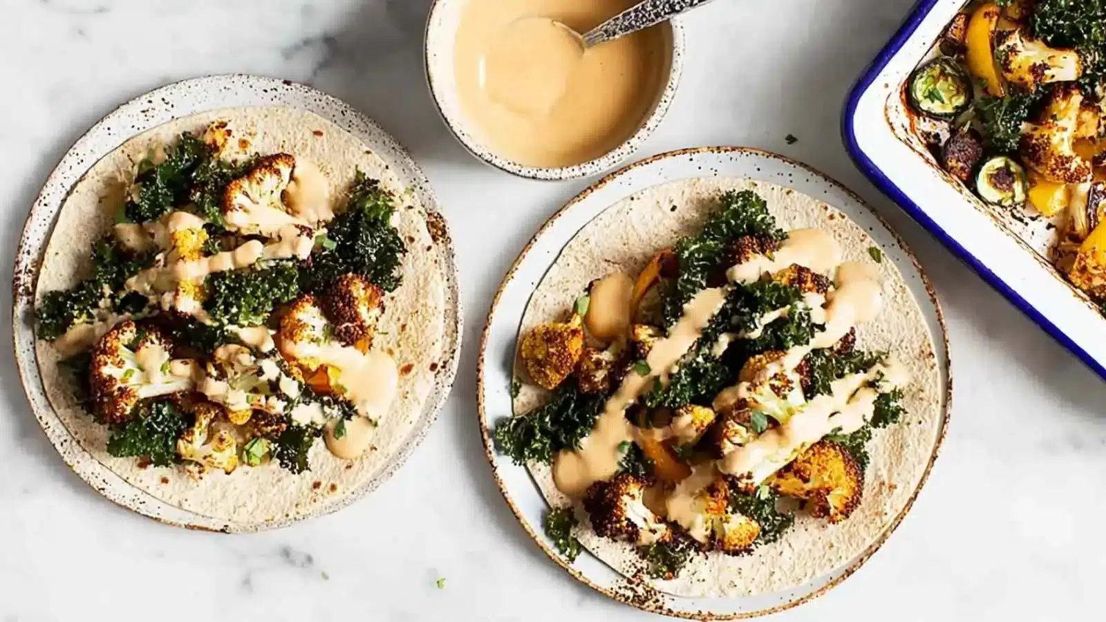 Smoky cauliflower wraps served with creamy cashew dip on a wooden board.