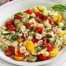 Colorful summer pasta salad with fresh vegetables and herbs