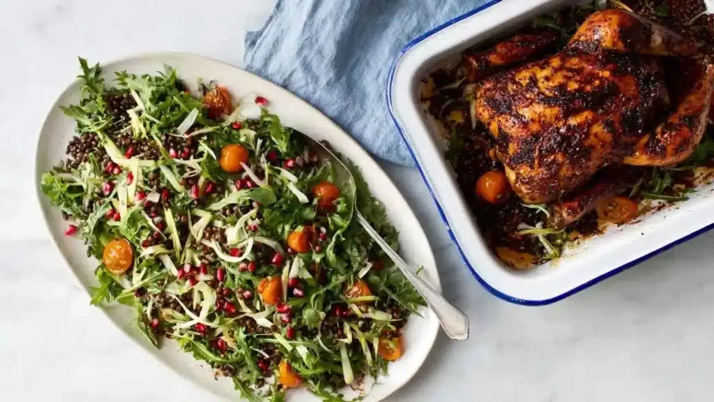 Delicious roast chicken served with a fresh lentil salad on a wooden table.