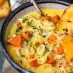 Bowl of creamy Chicken Macaroni Cheese Soup garnished with herbs