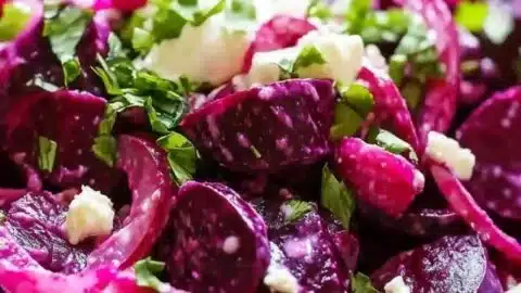 Cold beet salad topped with Greek yogurt dressing served in a bowl