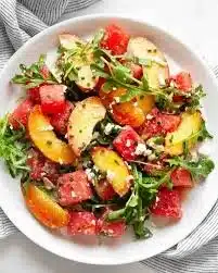 A vibrant bowl of easy summer peach watermelon salad with fresh ingredients.