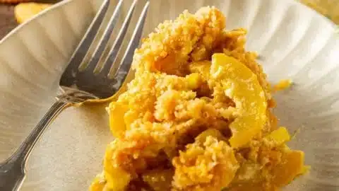 Southern Squash Casserole served in a rustic dish, garnished with herbs.