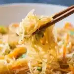 Spaghetti squash dish topped with protein and colorful vegetables