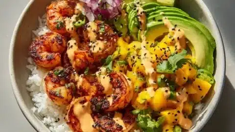Charred shrimp and avocado bowl topped with fresh ingredients for a healthy meal.