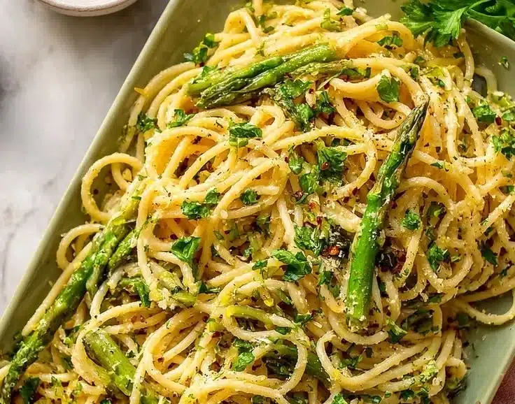 Zesty lemon asparagus pasta dish garnished with herbs in a bowl