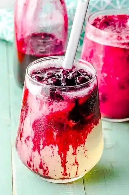 A refreshing glass of blueberry lemonade with fresh blueberries and lemon slices
