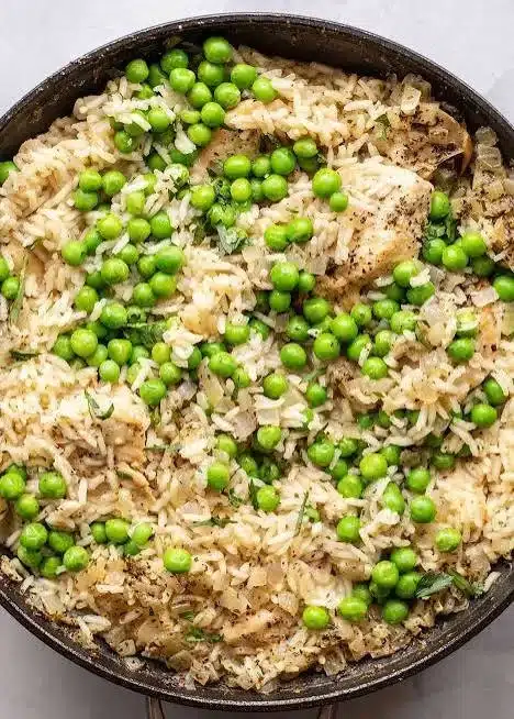 Delicious chicken rice skillet dish topped with vegetables and herbs
