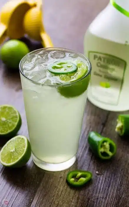 A refreshing Coconut Lime Drink served in a glass with ice and lime slices.