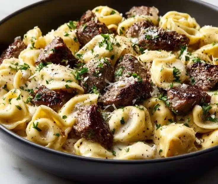 Plate of Cracked Garlic Steak Tortellini garnished with herbs