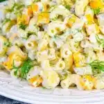 Delicious Dill Pickle Pasta Salad in a bowl with fresh herbs.