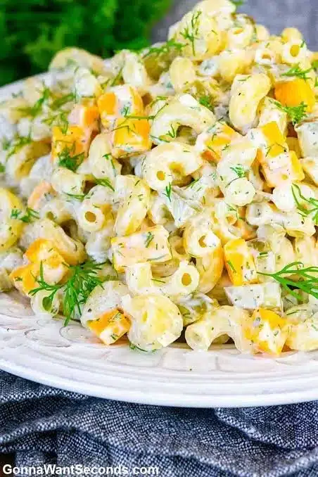 Delicious Dill Pickle Pasta Salad in a bowl with fresh herbs.