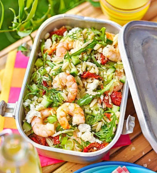 Vibrant bowl of fresh summer salad with colorful vegetables and herbs.