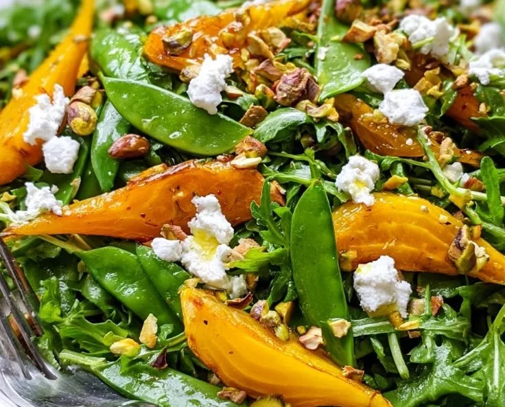 Colorful golden beet salad with fresh greens and dressing