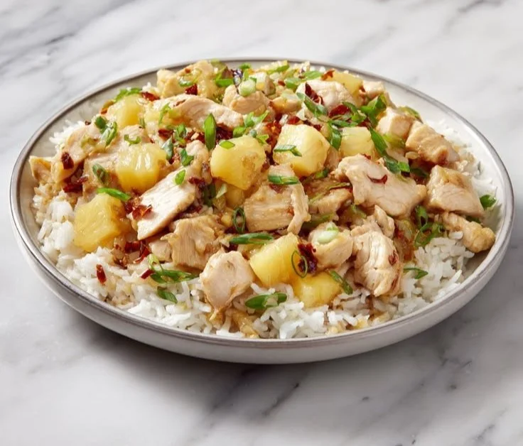 Delicious Pineapple Chicken and Rice served with colorful vegetables on a plate.