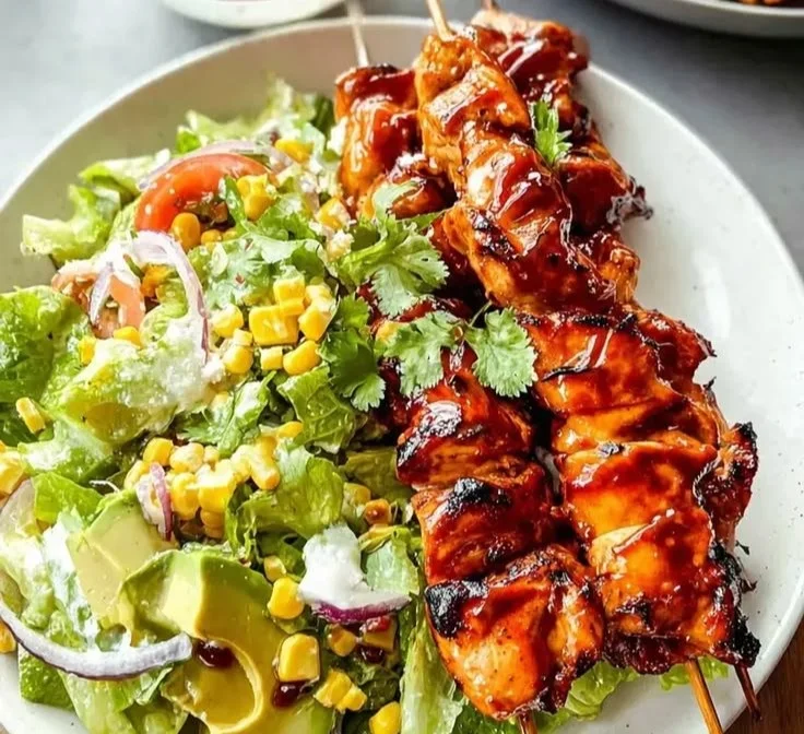 BBQ chicken skewer salad with fresh vegetables and herbs