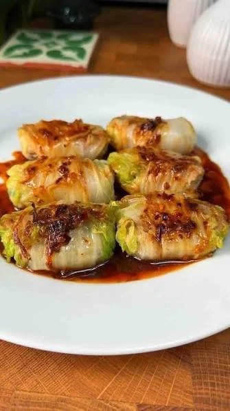 Delicious homemade cabbage dumplings served on a plate with herbs.
