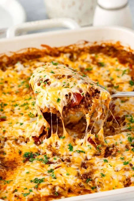 Cheesy Taco Rice Casserole with melted cheese and toppings in a baking dish