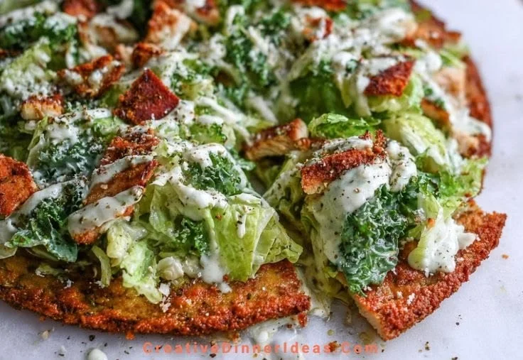 Chicken Caesar Salad Pizza topped with romaine lettuce, grilled chicken, and Caesar dressing