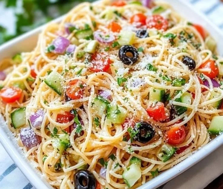 Chilled spaghetti salad with colorful vegetables in a bowl