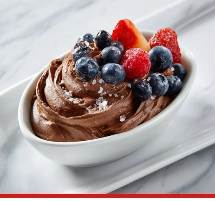 Creamy chocolate protein pudding in a bowl garnished with chocolate shavings