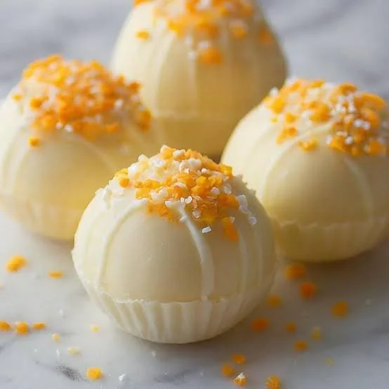 Delicious creamy lemon truffles garnished with zest, perfect for dessert lovers.