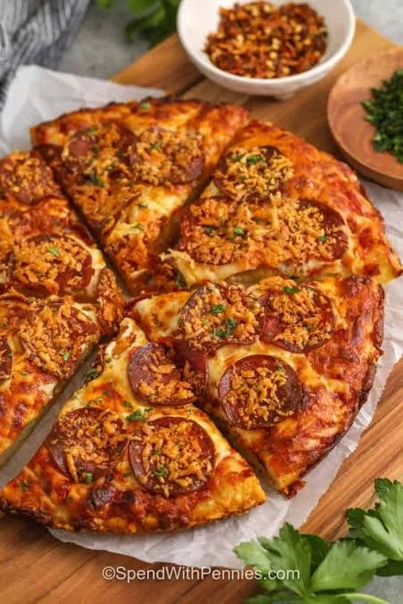 Crispy cast iron pizza with golden crust and fresh toppings on a wooden table