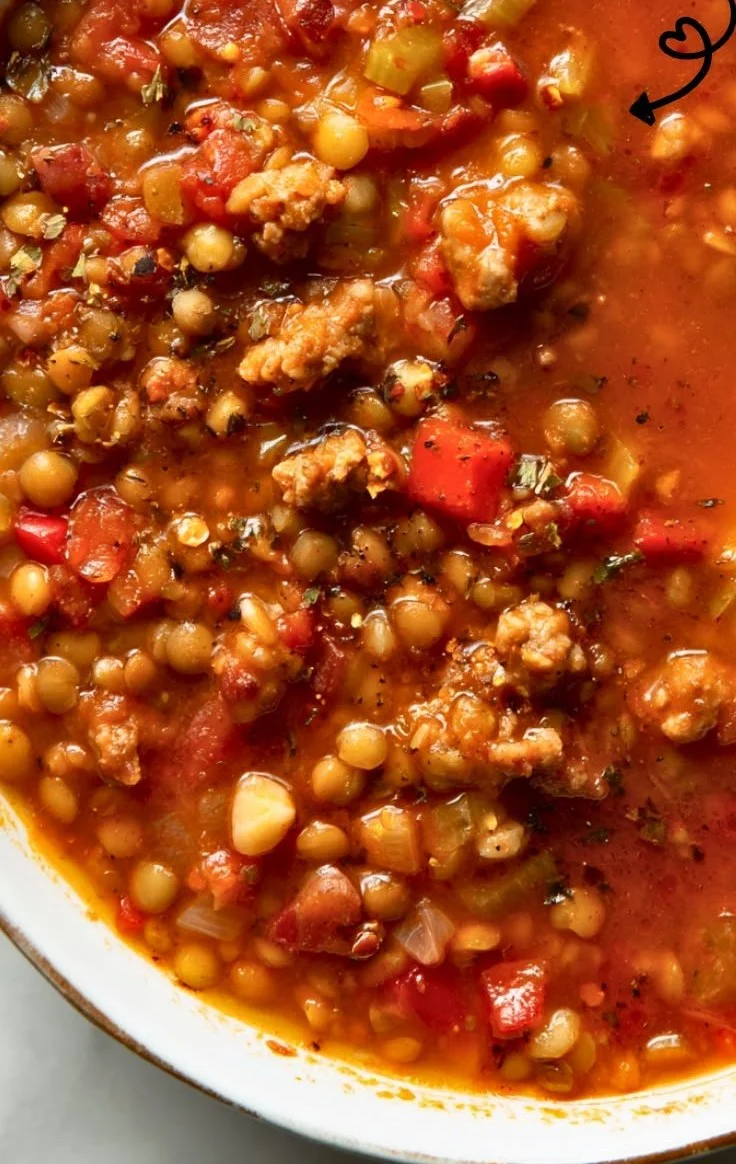 A bowl of easy sausage lentil soup with vegetables and herbs