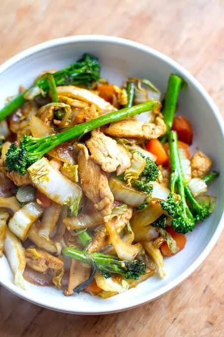 A plate of fried cabbage with chicken, garnished and ready to be served.