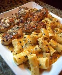 Creamy Garlic Butter Chicken Rigatoni served in a bowl with fresh herbs.