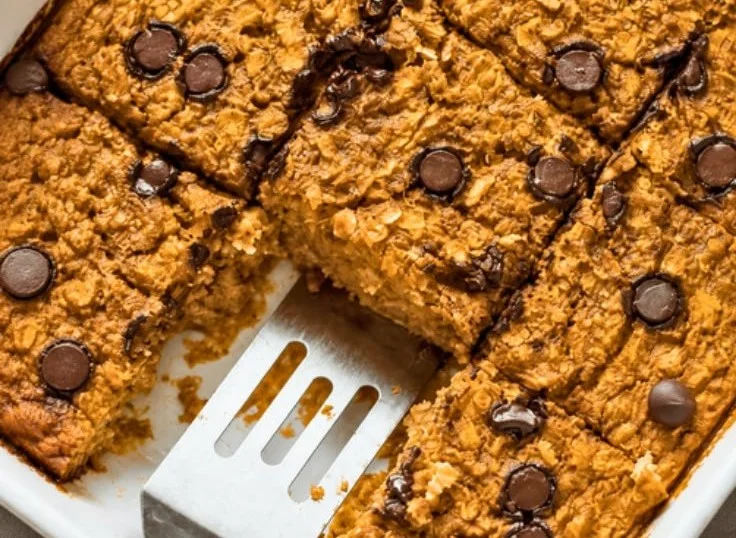 A bowl of healthy pumpkin baked oatmeal topped with nuts and spices