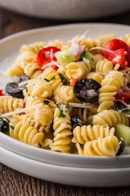 Bowl of Italian pasta salad with olives, vegetables, and dressing