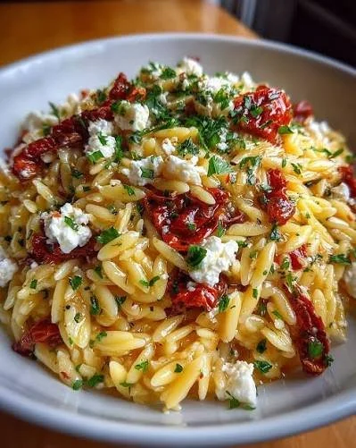 Delicious orzo pasta salad with feta cheese and sun dried tomatoes.